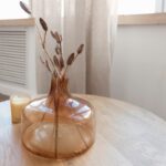 Photo by Katsia Jazwinska a table with a vase and candle on it