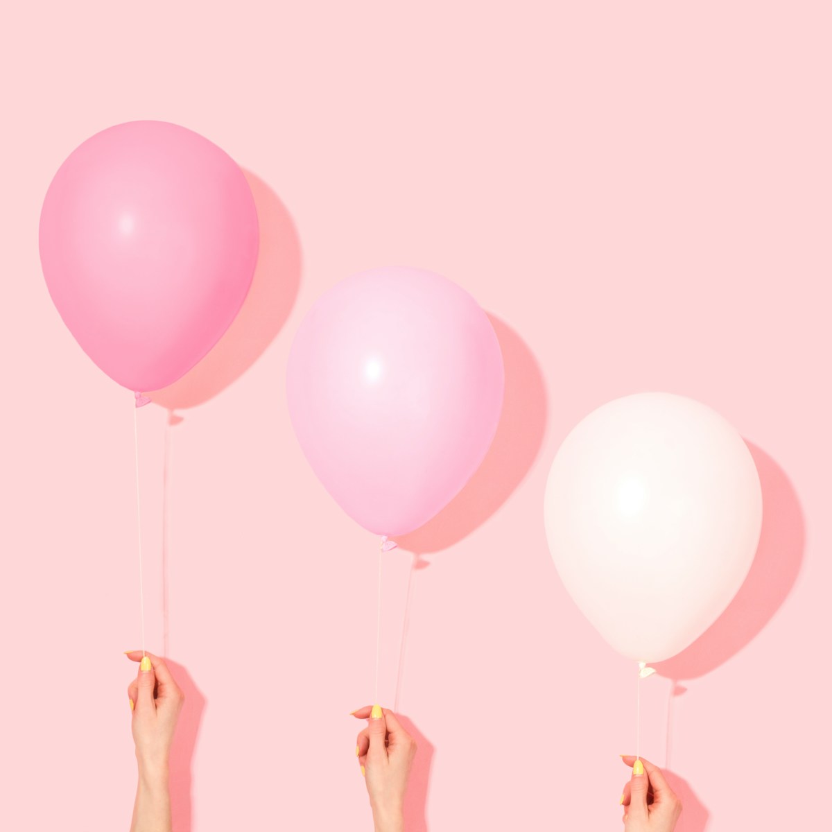 Photo by Shamblen Studios person holding pink and white balloon