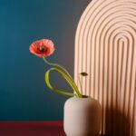 Photo by Linh Le a small vase with a single flower in it